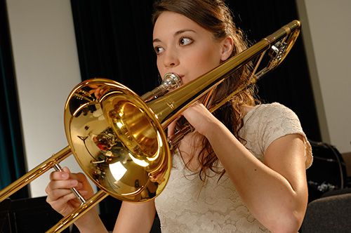 A girl playing a step-up Yamaha trombone.